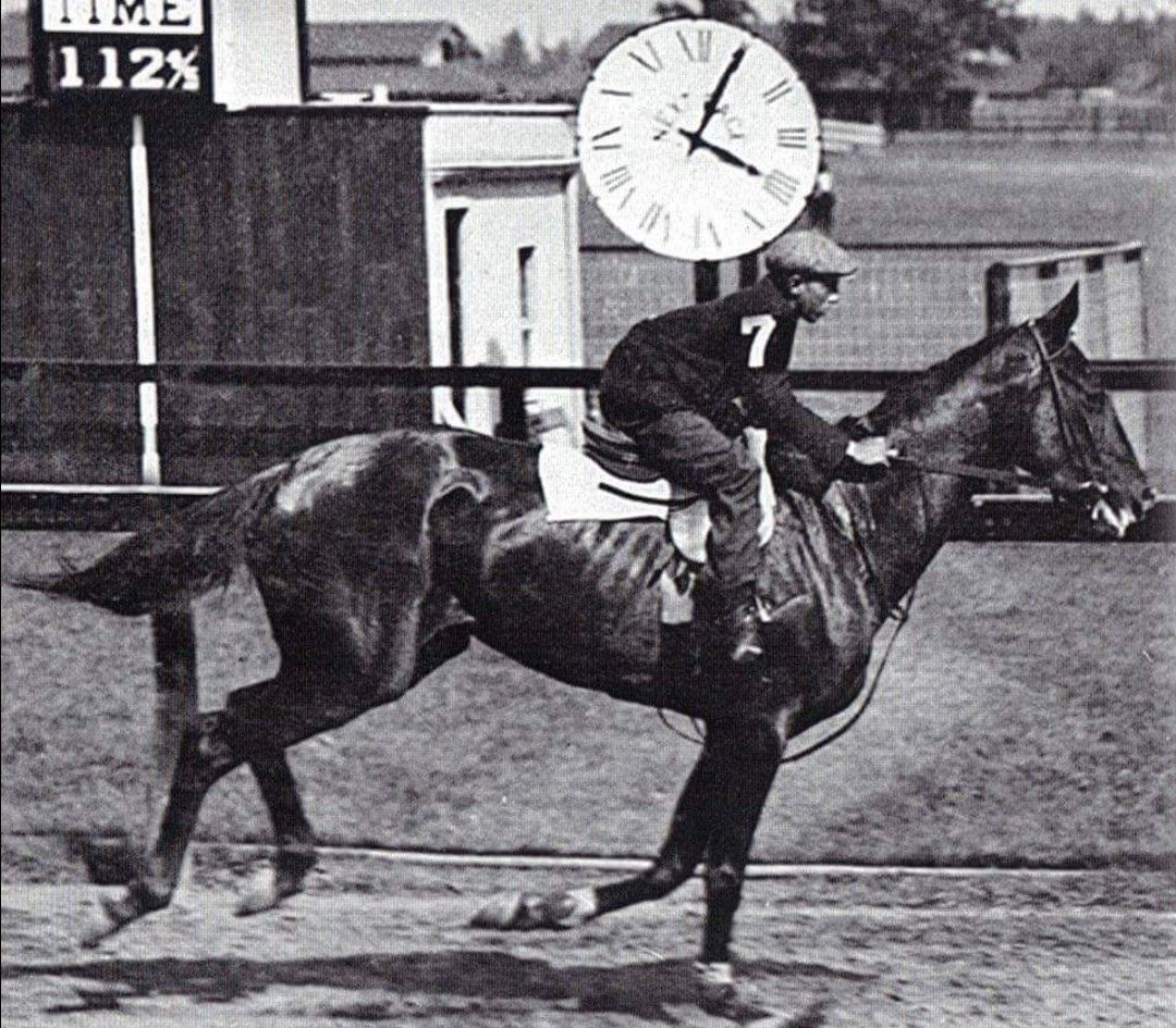 A black-and-white photo of the filly Whimsical galloping.