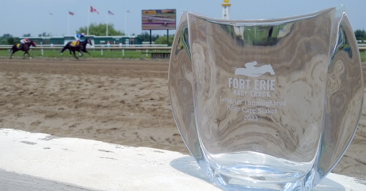 A crystal trophy with the racetrack behind.