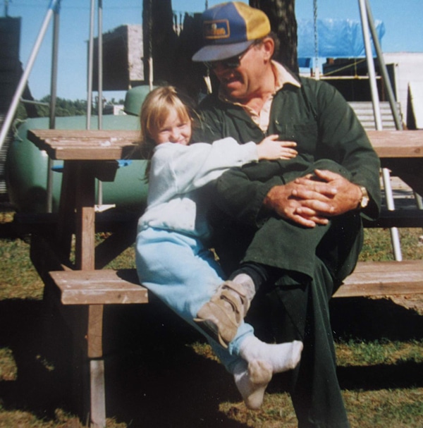 A little girl hugging her grandpa.