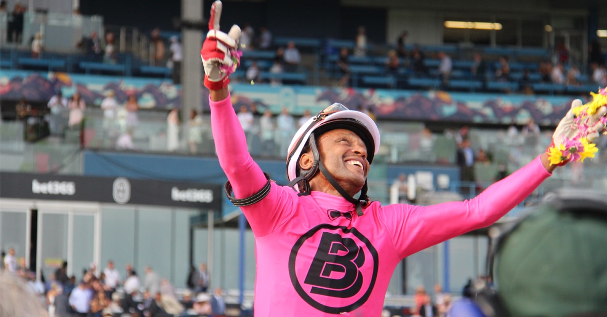 A jockey with his hands in the air.