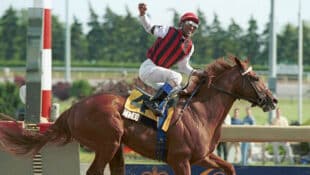 A jockey on a chestnut horse winning a race at Woodbine in 2003.