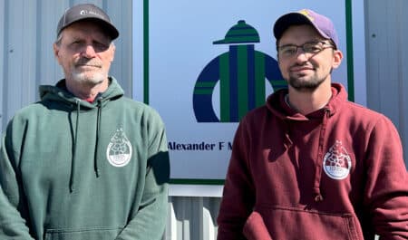 Two men standing in front of a sign at Woodbine.